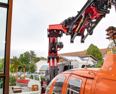 Mit höchster Präzision wird der Hubschrauber mit dem Kran durch den Eingang des Museums gehoben.