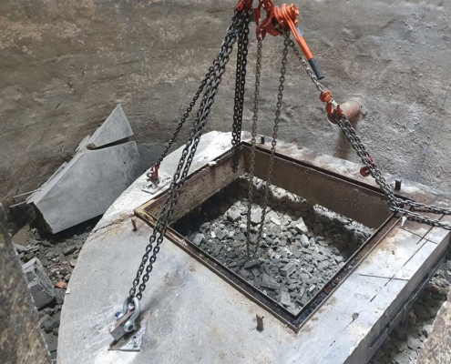 Ein Teil einer Betonplatte wird mit dem Kran entfernt.
