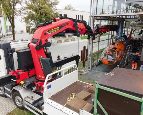 Mit höchster Präzision wird der Hubschrauber mit dem Kran durch den Eingang des Museums gehoben.