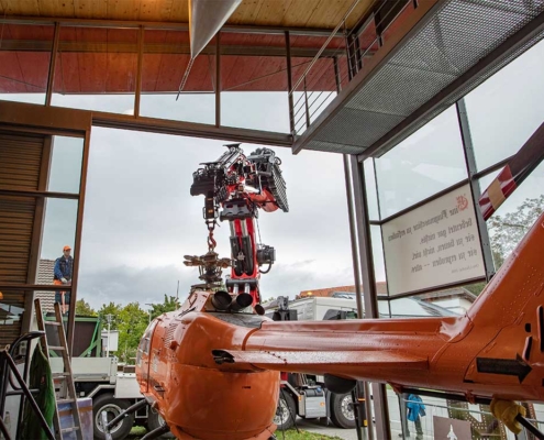 Mit höchster Präzision wird der Hubschrauber mit dem Kran durch den Eingang des Museums gehoben.