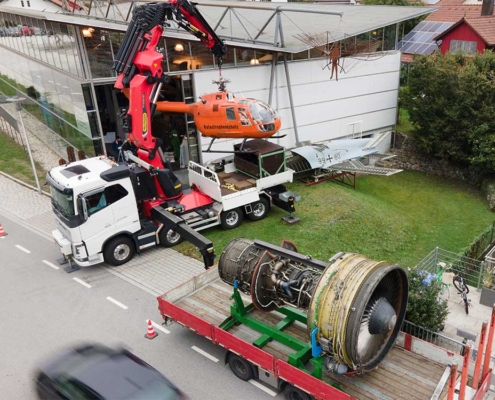 Der Hubschrauber wird mit dem Kran versetzt, sodass die Flugzeugturbine an ihren Platz gebracht werden kann.