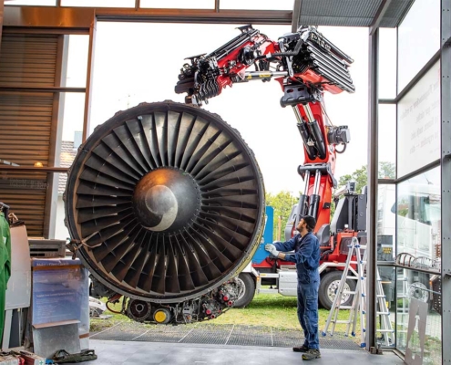 Die Flugzeugturbine wird mit dem Kran im Museum platziert. Herausforderung war hier unter anderem die empfindliche Glasarchitektur des Gebäudes.