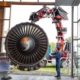 Die Flugzeugturbine wird mit dem Kran im Museum platziert. Herausforderung war hier unter anderem die empfindliche Glasarchitektur des Gebäudes.